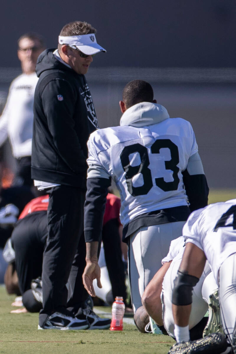 Raiders head coach Josh McDaniels speaks to tight end Darren Waller (83) during practice at the ...
