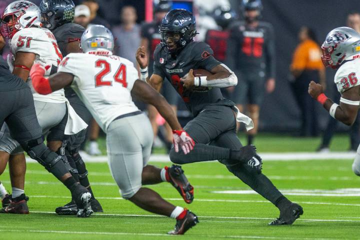 UNLV Rebels quarterback Doug Brumfield (2) looks for more yards on a run as New Mexico Lobos sa ...