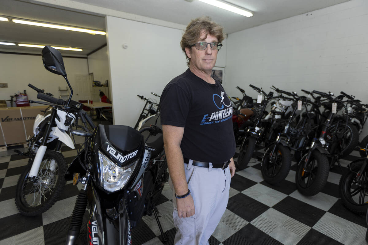 John Reagan, owner of E-Power Sport, poses for a portrait at his e-bike shop showroom floor in ...