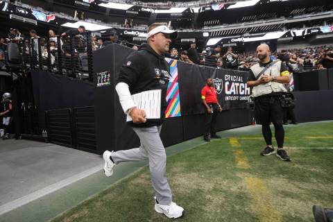 Raiders head coach Josh McDaniels runs onto the field before an NFL game against the Houston Te ...