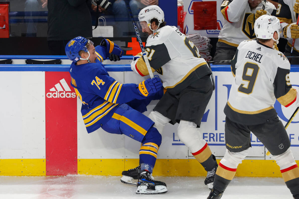 Buffalo Sabres center Rasmus Asplund (74) is checked by Vegas Golden Knights right wing Mark St ...
