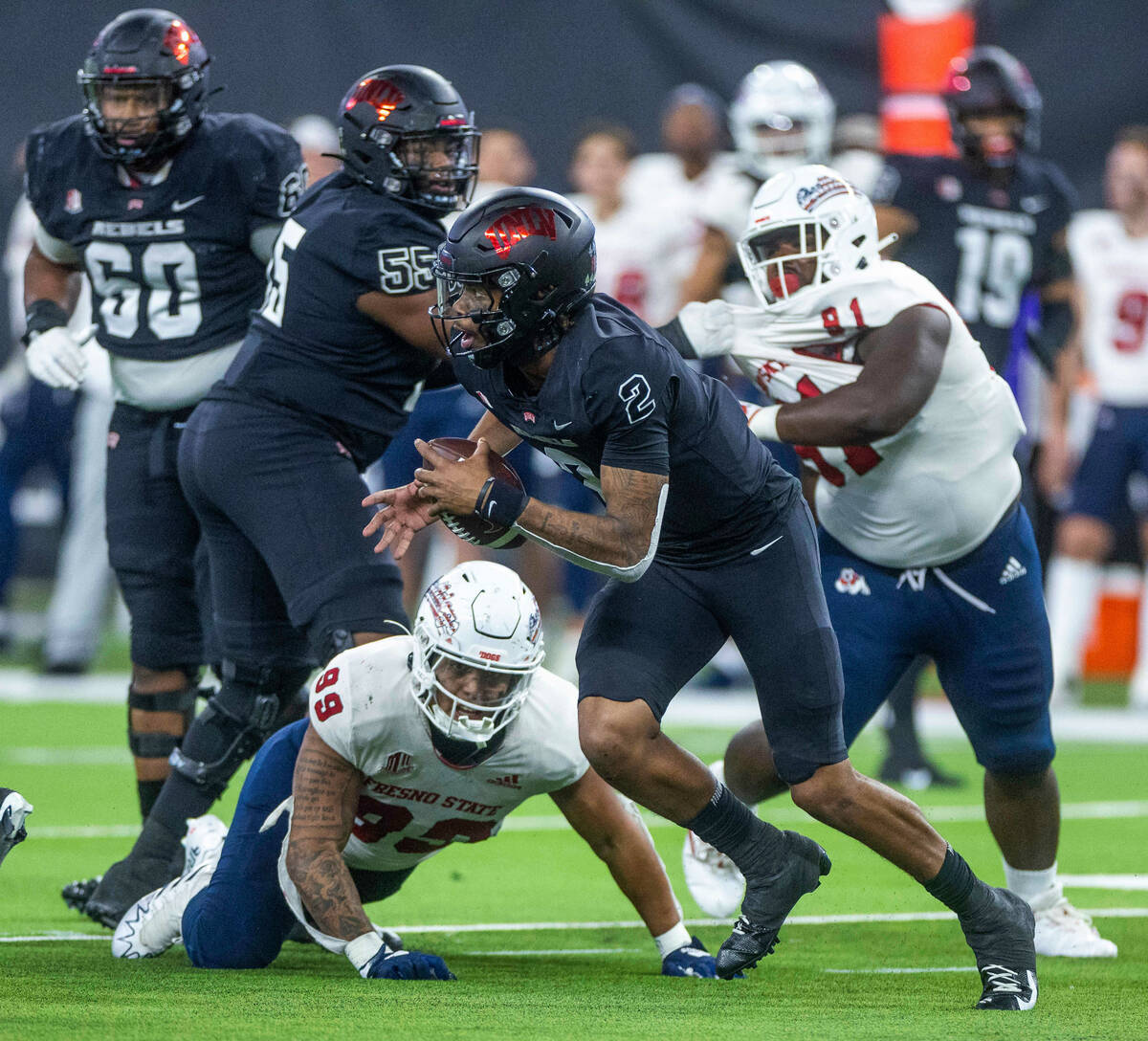 UNLV Rebels quarterback Doug Brumfield (2) scrambles away from Fresno State Bulldogs defensive ...