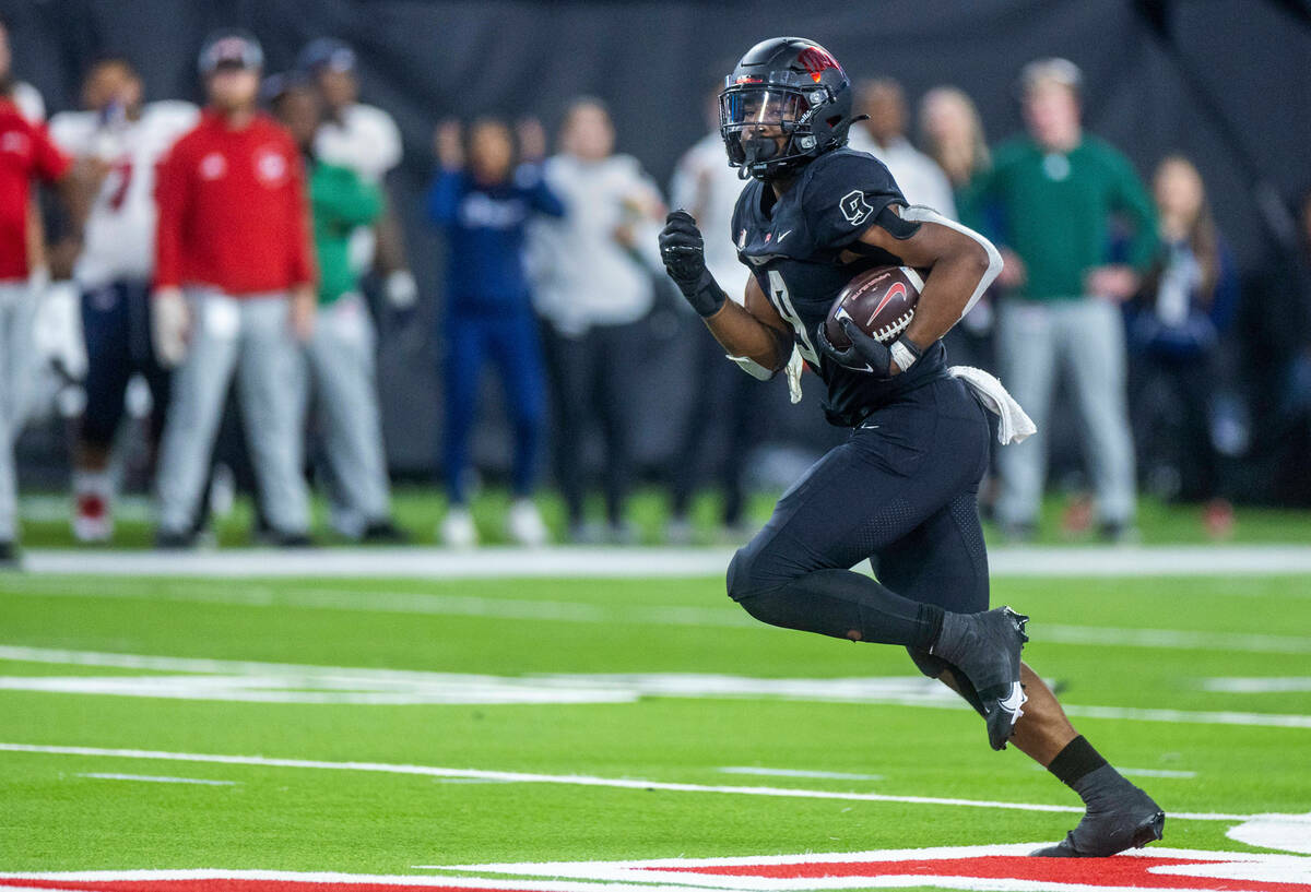 UNLV Rebels running back Aidan Robbins (9) pulls away from Fresno State Bulldogs defenders on t ...