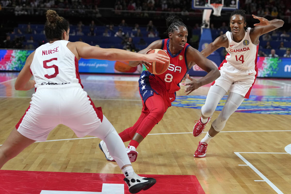 United States' Chelsea Gray, center, splits Canada's Kia Nurse, left, and Kayla Alexander durin ...