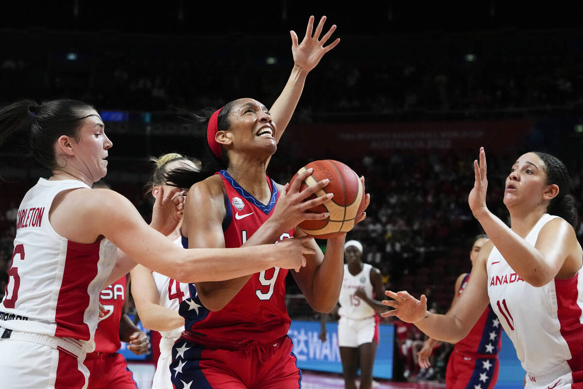 United States' A'ja Wilson lays up for a shot at goal as Canada's Bridget Carleton, left, and N ...