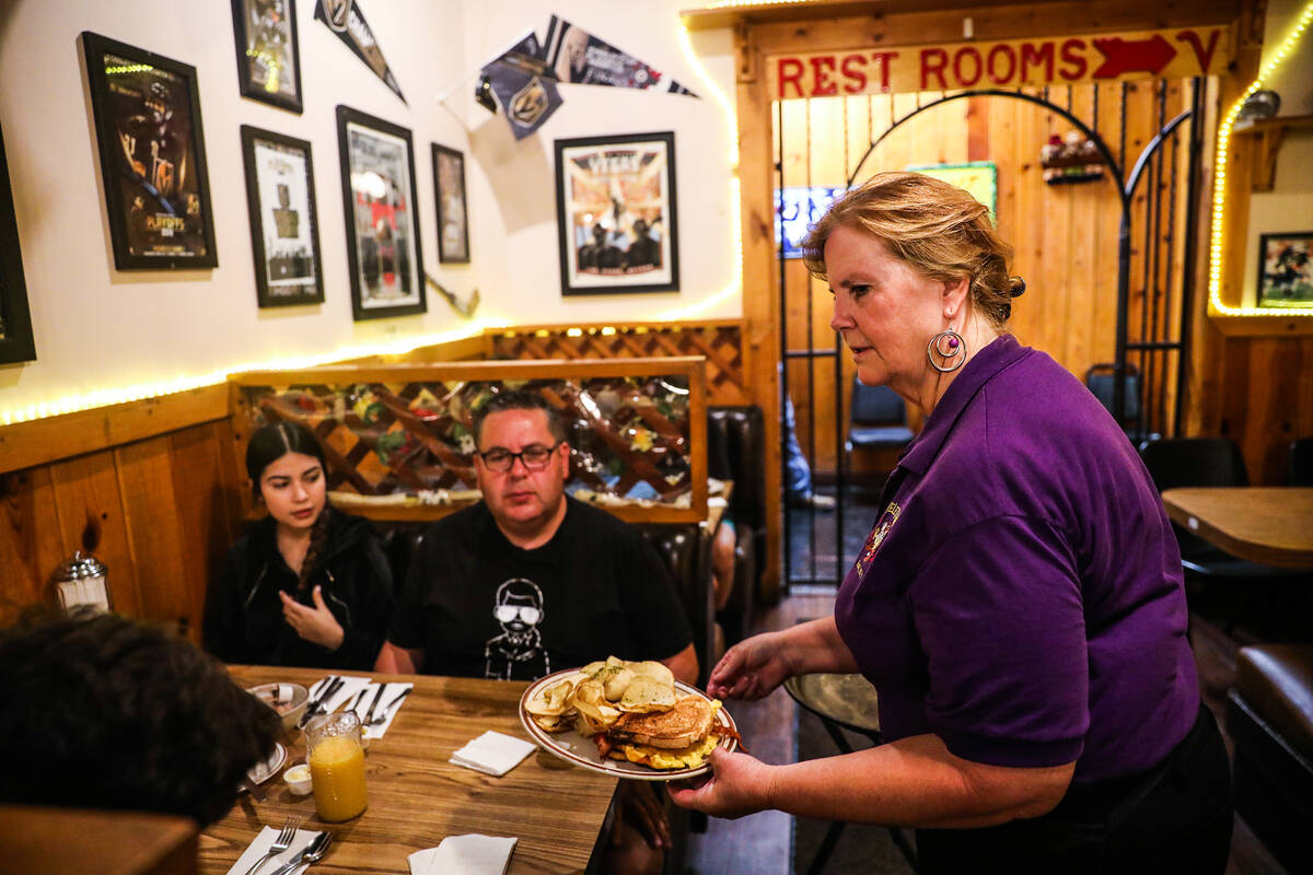 Server Katy Lehmann brings food to a family dining at The Omelet House at their central Las Veg ...