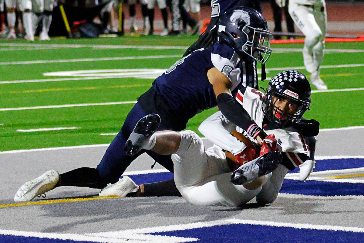 Las Vegas’ Garrett Hughes, right, scores a touchdown over Shadow Ridge’s Jonah Ruiz, left, ...