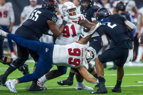 Fresno State Bulldogs defensive end David Perales (99) dives in an attempt to sack UNLV Rebels ...