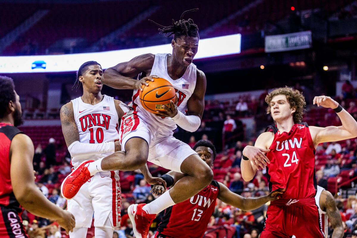 UNLV Rebels forward Victor Iwuakor (0) pulls down a rebound over Incarnate Word Cardinals guard ...
