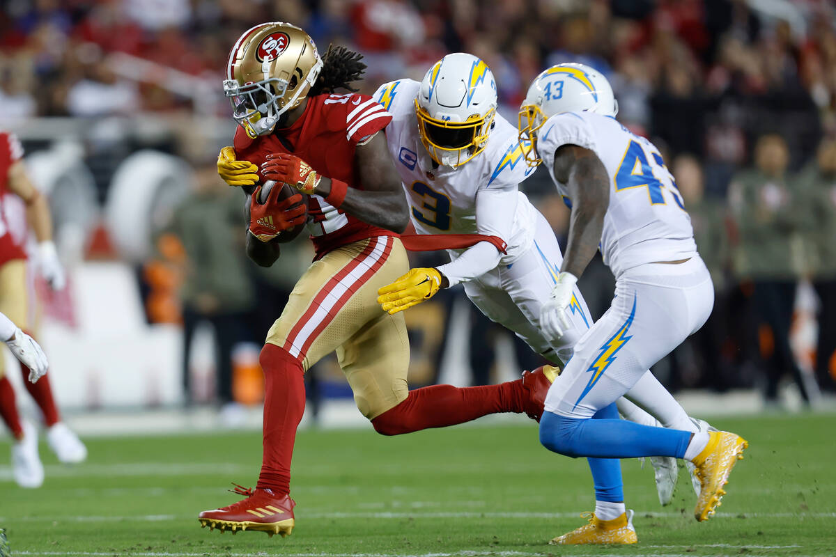 San Francisco 49ers wide receiver Brandon Aiyuk, left, runs against Los Angeles Chargers safety ...