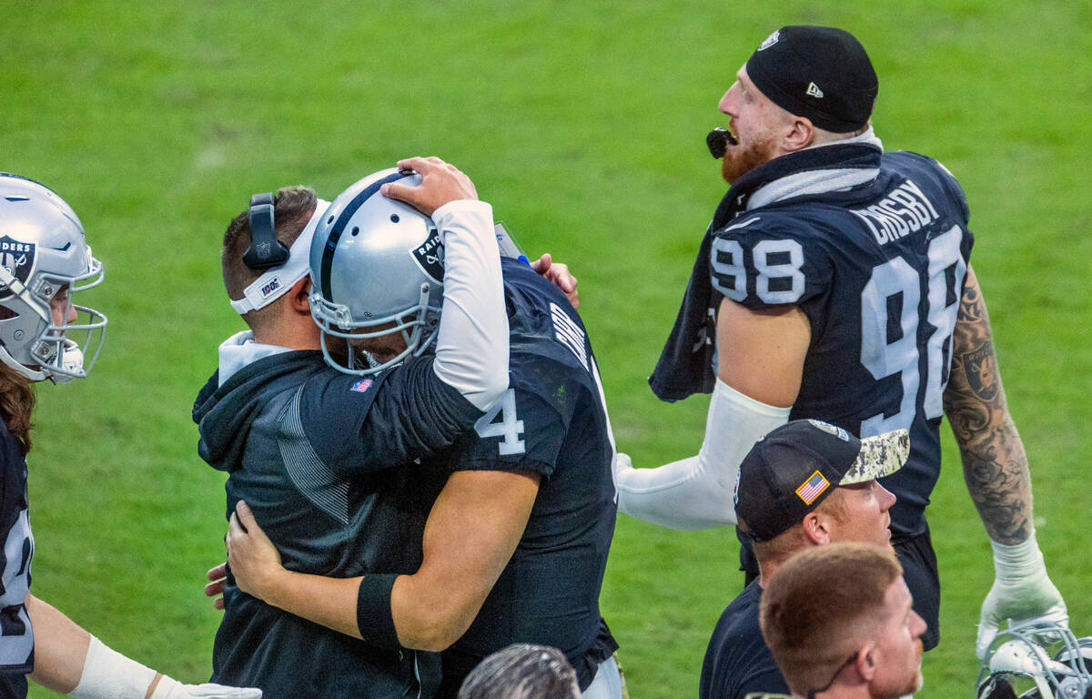 Raiders Head Coach Josh McDaniels embraces quarterback Derek Carr (4) on the sidelines versus t ...