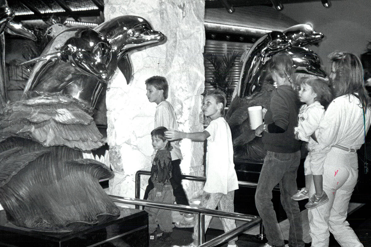 Sculpted dolphins greet visitors at the main entrance of The Mirage on its opening day on Nov. ...