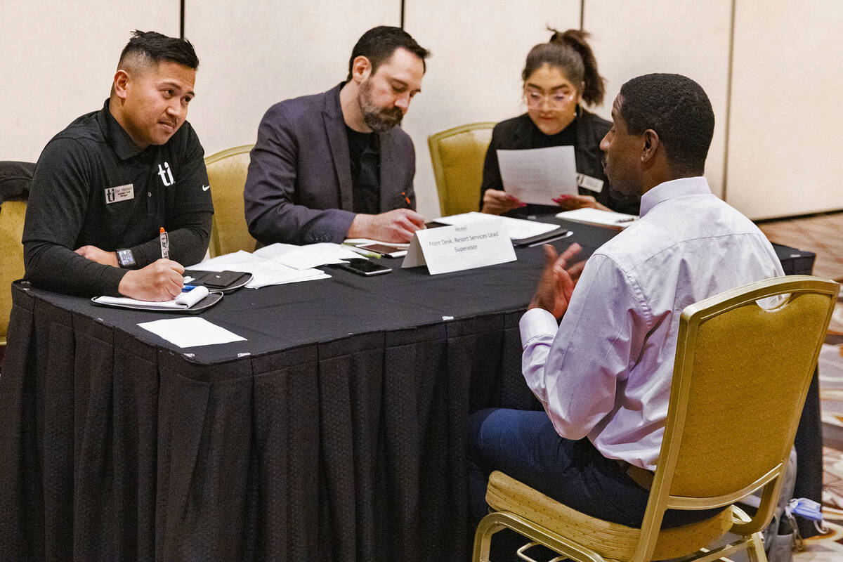 Earl Mamaril, left, assistant hotel manager at Treasure Island, and Eliot Stack, center, listen ...