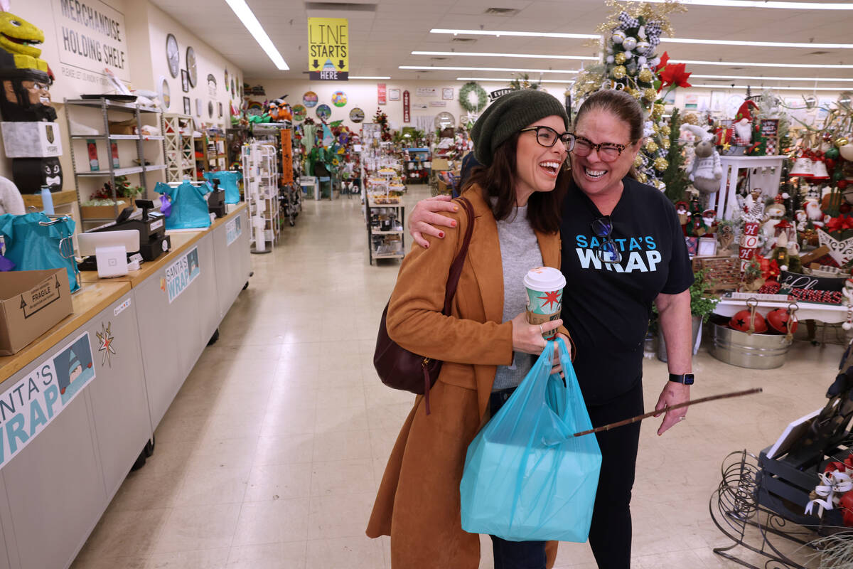 Co-owner Beth Tom, right, hugs customer Brittney Aquino of Henderson shop at Santa’s Wrap hom ...