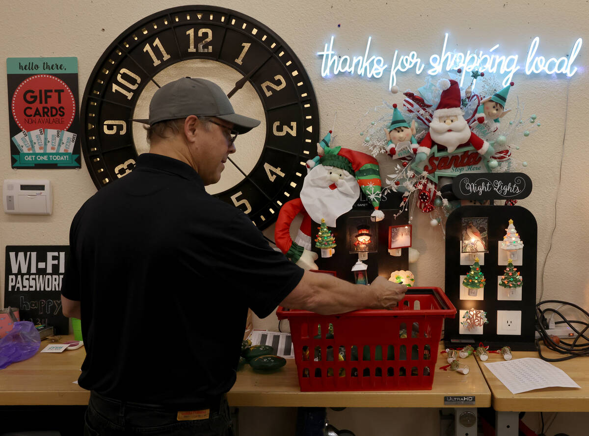 Co-owner Dave Kimler prices merchandise at Santa’s Wrap home decor and furniture store in Las ...