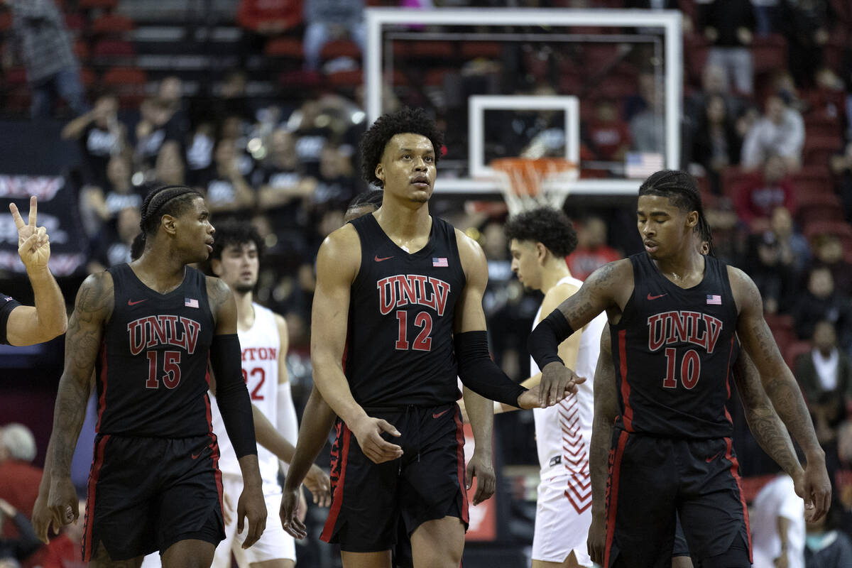 UNLV Rebels center David Muoka (12) slaps hands with guard Keshon Gilbert (10) after referees c ...