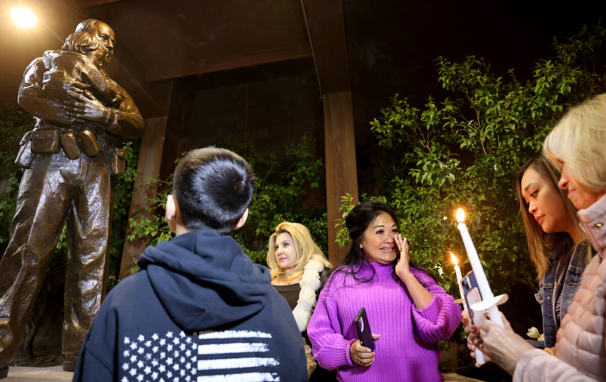 Minddie Lloyd, widow of Las Vegas police Lt. Erik Lloyd, center, reacts as a statue honoring he ...