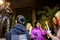 Minddie Lloyd, widow of Las Vegas police Lt. Erik Lloyd, center, reacts as a statue honoring he ...