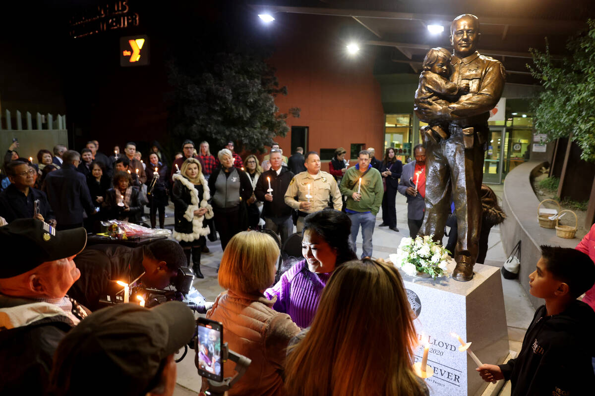 Minddie Lloyd, widow of Las Vegas police Lt. Erik Lloyd, hugs Carol Luther during the unveiling ...
