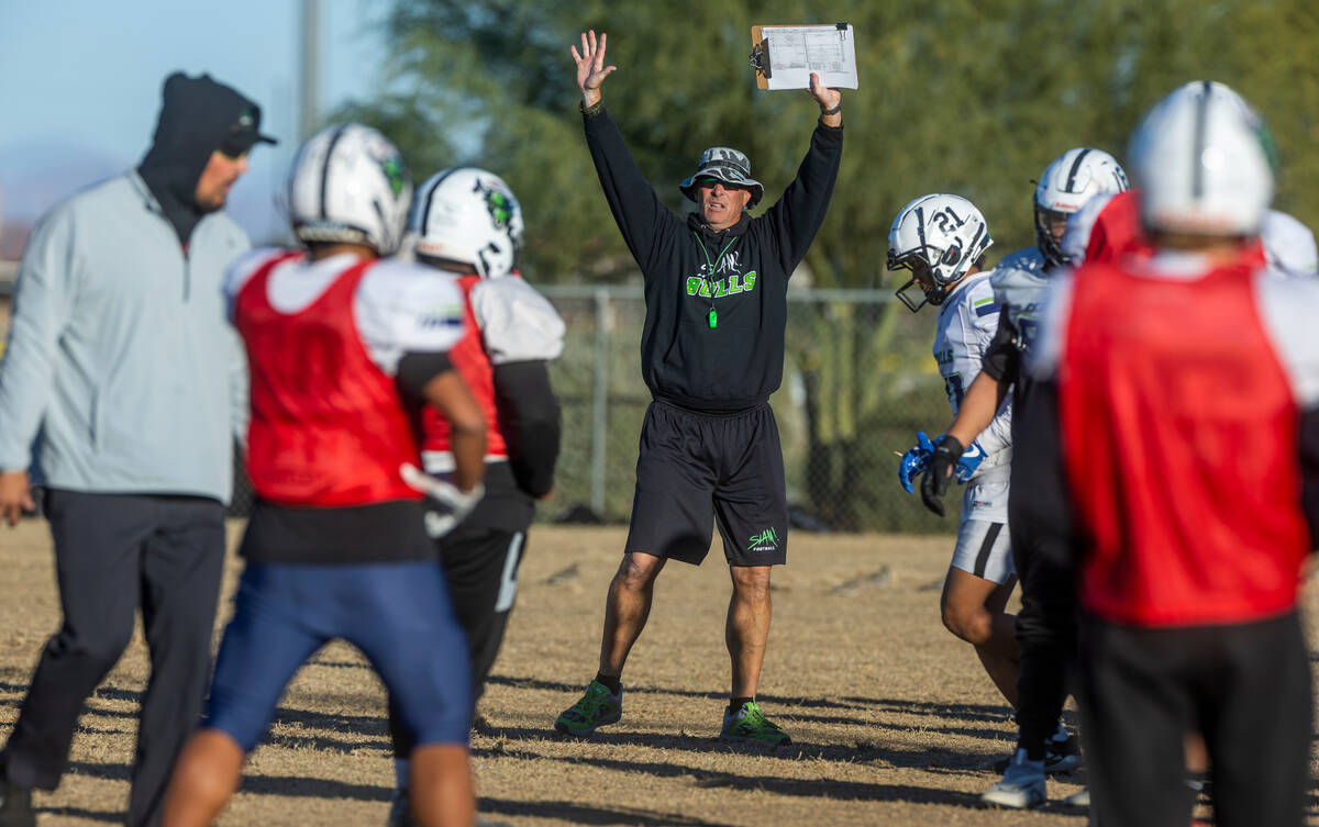 SLAM Academy Head Coach Mike Cofer, center, counsels his players during football practice while ...