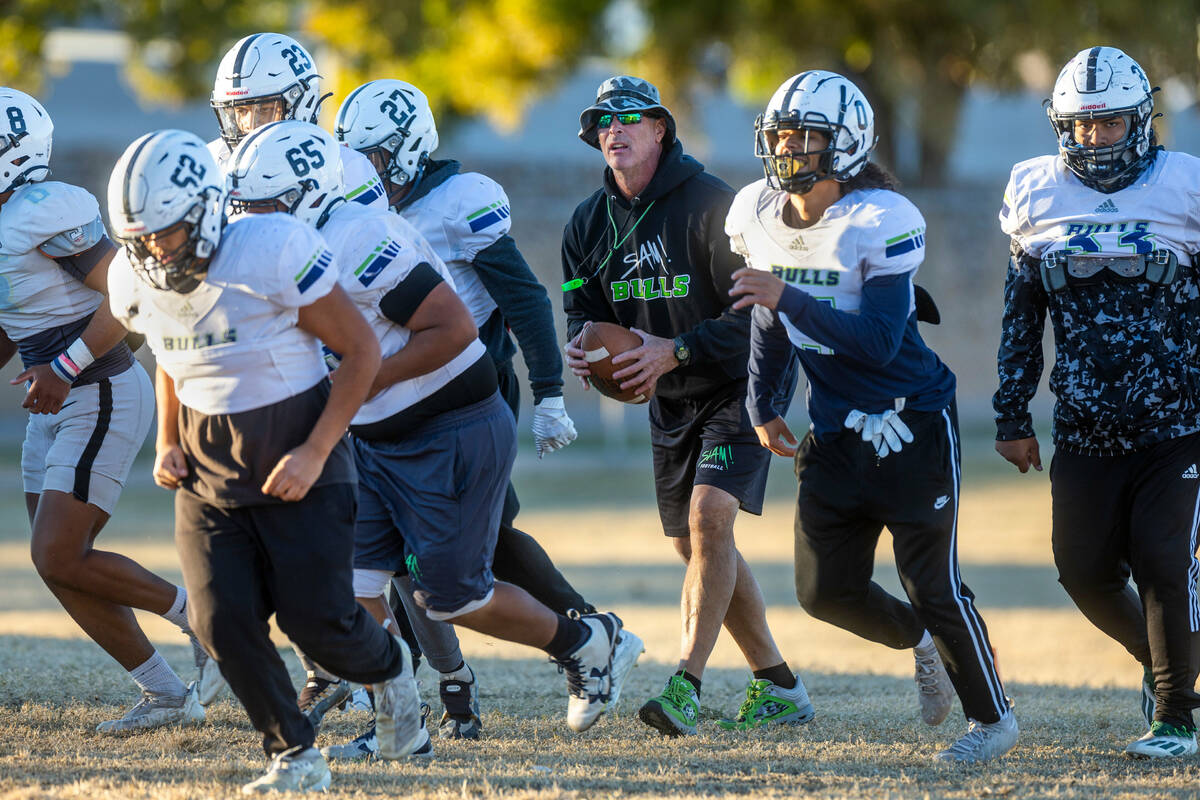 SLAM Academy Head Coach Mike Cofer, center, on a possession drill during football practice whil ...