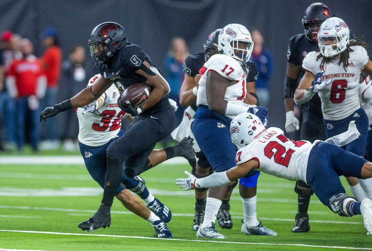 UNLV Rebels running back Aidan Robbins (9) leaps from a tackle attempt by Fresno State Bulldogs ...