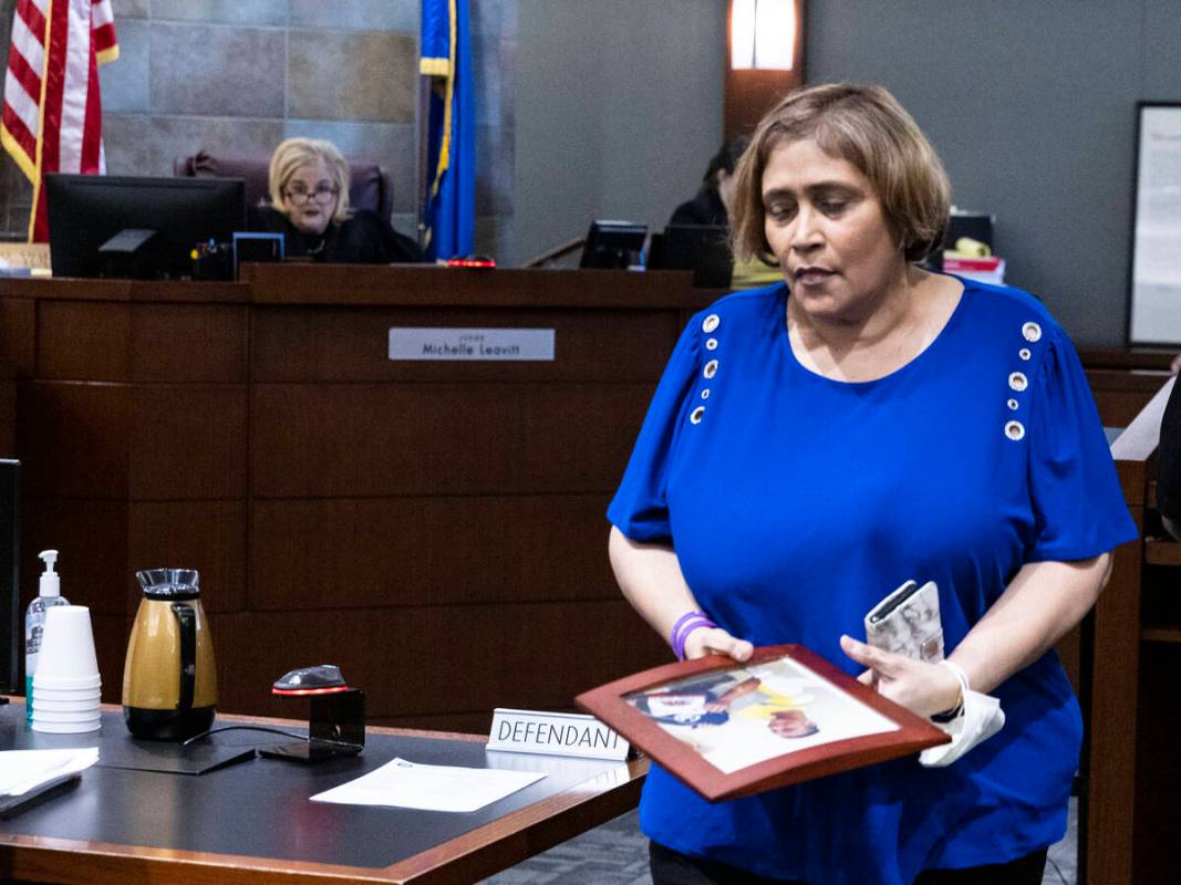 Veronica Melton, the mother of shooting victim Giovanni, holds her son's photograph as she leav ...