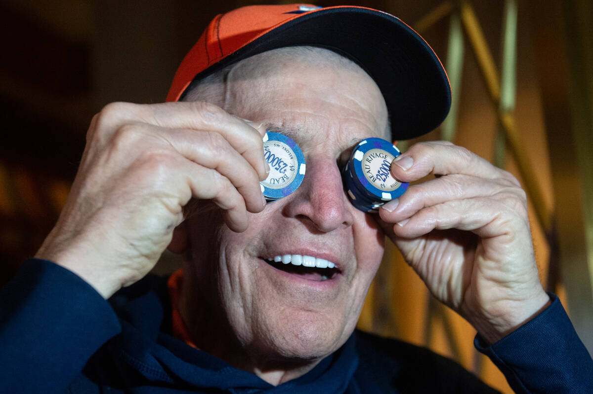 Jim McIngvale, better known as "Mattress Mack," holds up $25,000 chips over his eyes ...