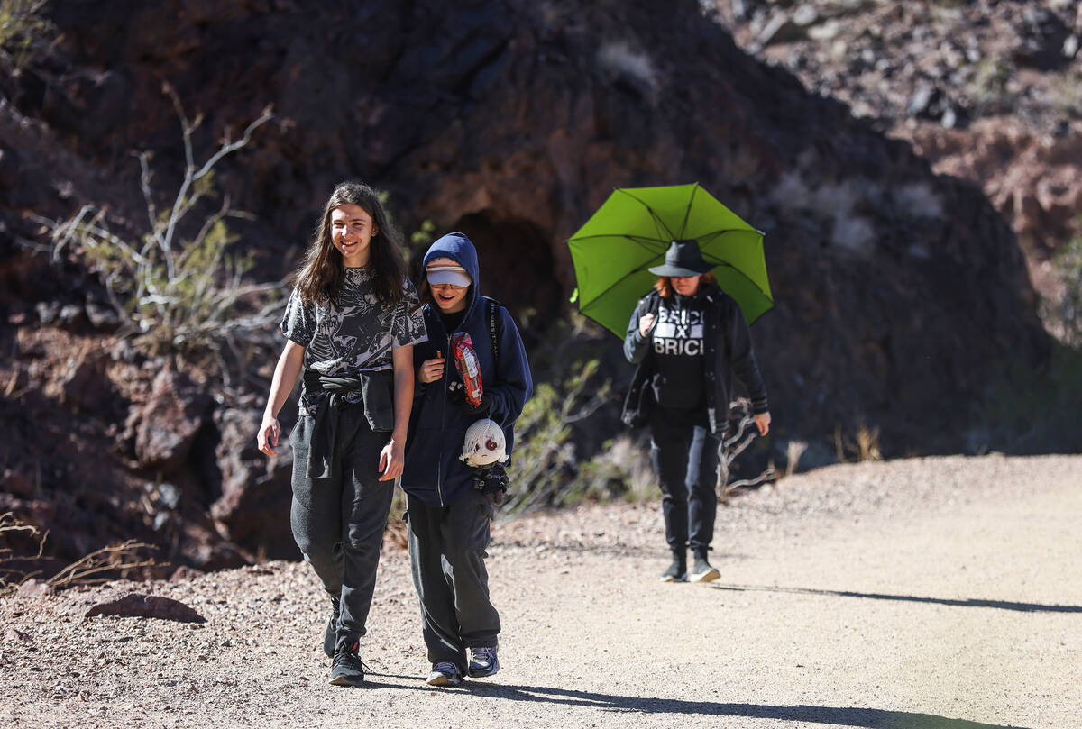 Student Alex Zimmerman, 15, left, walks with his sister Jayden Zimmerman, 17, right, in front o ...