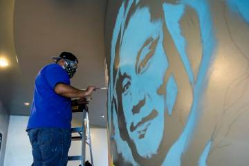 Artist Miguel Hernandez paints a mural in memory of Tony Hsieh in the lobby of ART HOUZ Theater ...