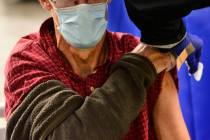A man receives a flu shot in Brattleboro, Vt., on Tuesday, Oct. 26, 2021. Health authorities ar ...