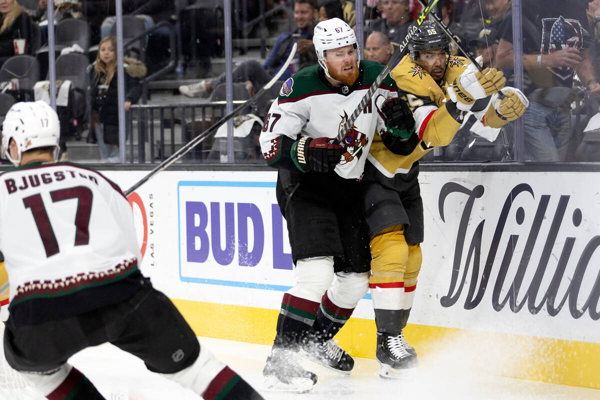 Coyotes left wing Lawson Crouse (67) slams Golden Knights right wing Keegan Kolesar (55) into t ...