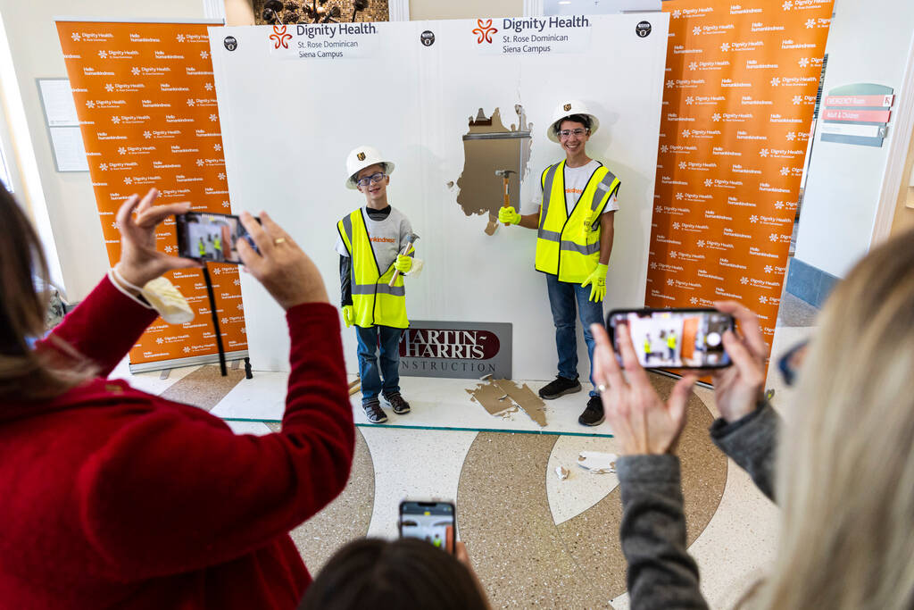 Former patients Landon DeFriez, 9, left, and James Kish, 14, pose after using a hammer to hit a ...