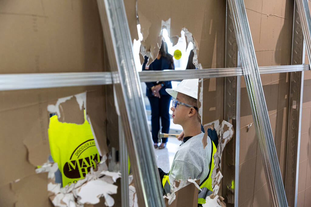 Former patient Landon DeFriez, 9, poses for a photo after using a hammer to hit a wall in the e ...