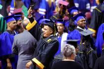 Clark High School student Isaac Juarez, bottom/middle, celebrates with classmates after turning ...