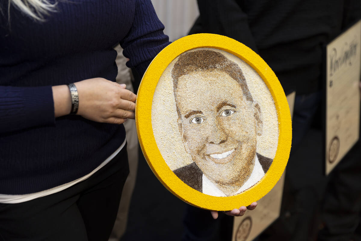Joanna May holds a floragraph of her late husband and Nevada Highway Patrol trooper Micah May, ...