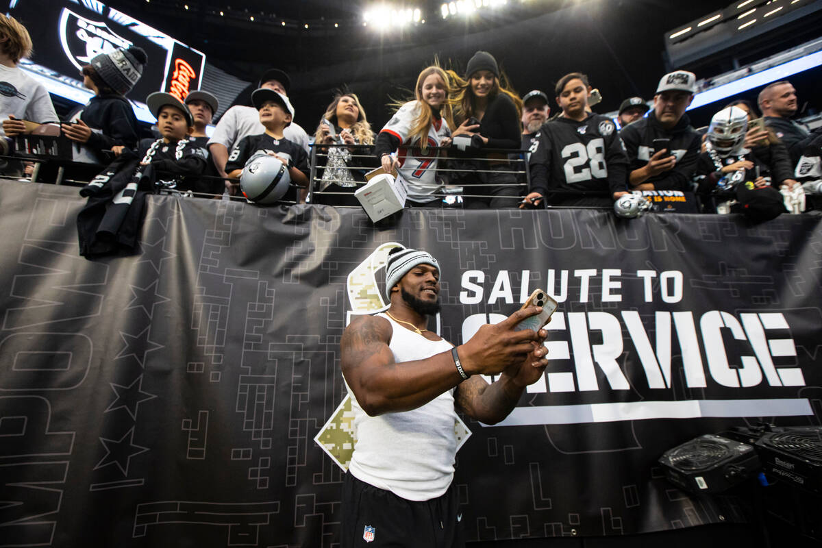 Las Vegas Raiders linebacker Denzel Perryman takes a selfie with fans before an NFL game at All ...
