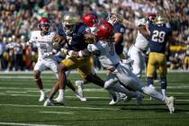 Notre Dame running back Audric Estime (7) stiff arms UNLV defensive back Johnathan Baldwin (3) ...