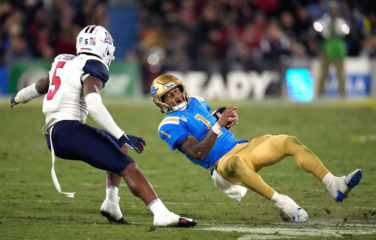 UCLA quarterback Dorian Thompson-Robinson, right, slips as he runs the ball while under pressur ...