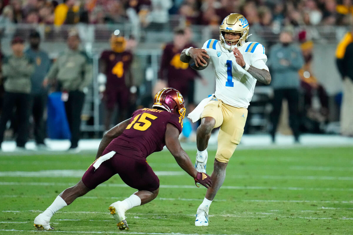 UCLA quarterback Dorian Thompson-Robinson (1) starts his leap over Arizona State defensive back ...