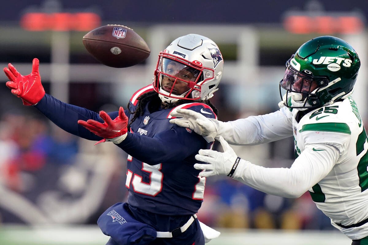 New England Patriots safety Kyle Dugger, left, reaches for the ball against New York Jets runni ...