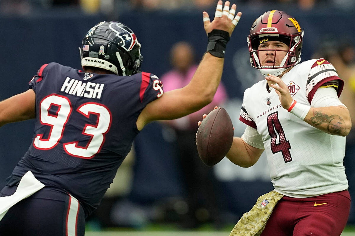 Washington Commanders quarterback Taylor Heinicke (4) looks to throw as Houston Texans defensiv ...
