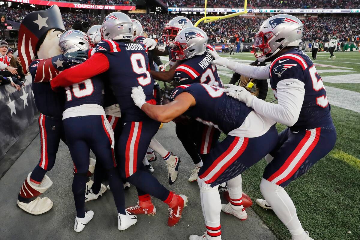 The New England Patriots celebrate the touchdown punt return by cornerback Marcus Jones during ...