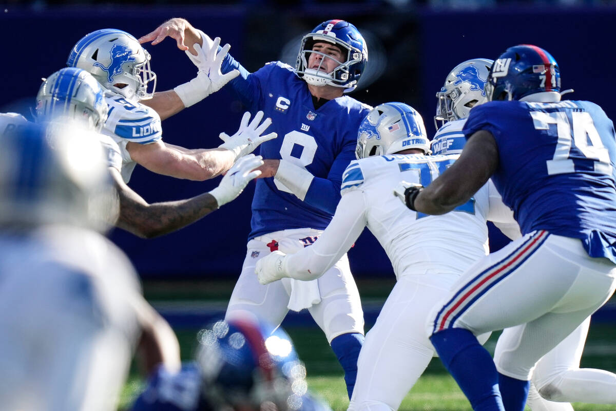 New York Giants quarterback Daniel Jones (8) passes under pressure during the first half of an ...