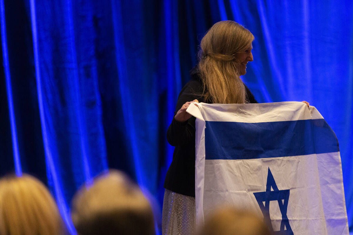An attendee holds up the Israeli flag as Benjamin Netanyahu, Israel’s Likud party leader ...