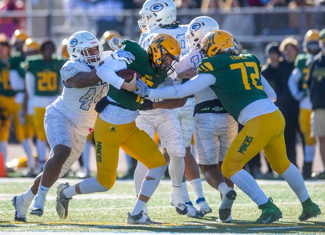 Bishop Gorman DL Aiden McComber (44) wraps up Bishop Manogue QB Logan Howren (15) for a sack du ...