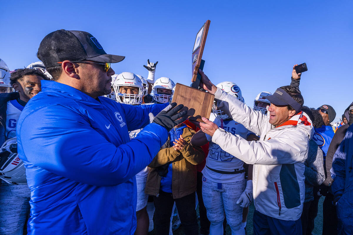 Bishop Gorman head coach Brent Browner receives the winning trophy from NIAA Executive Director ...