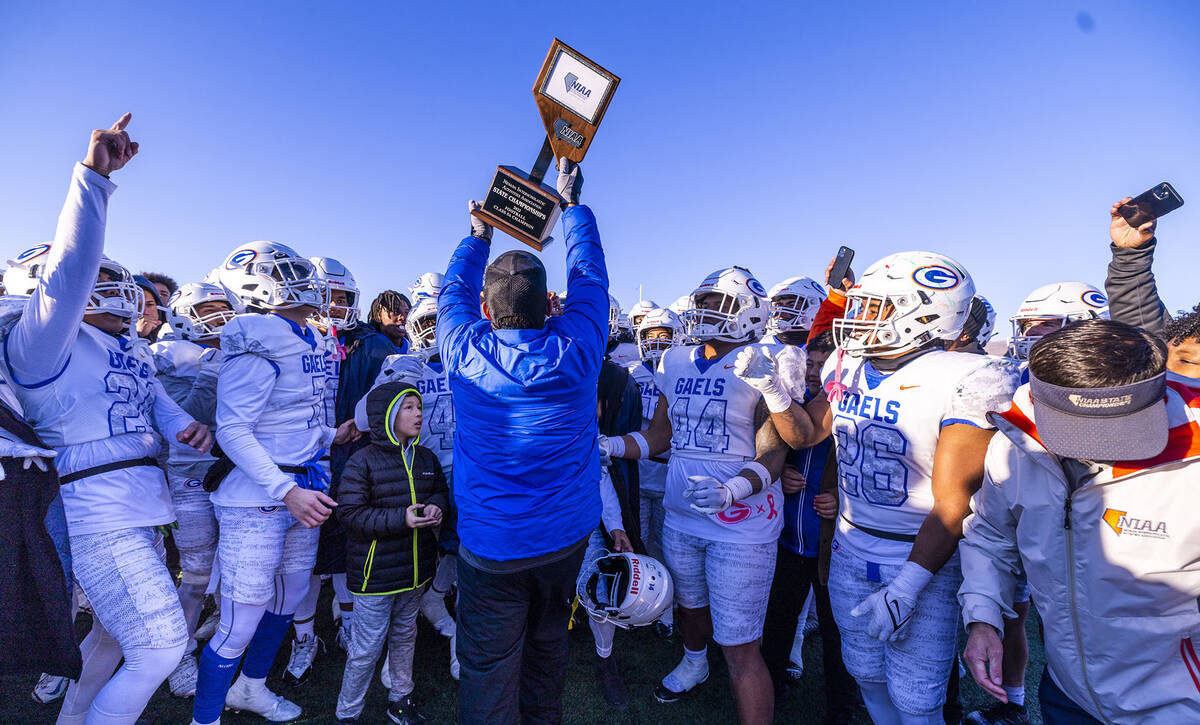 Bishop Gorman head coach Brent Browner presents the winning trophy to his players after defeati ...