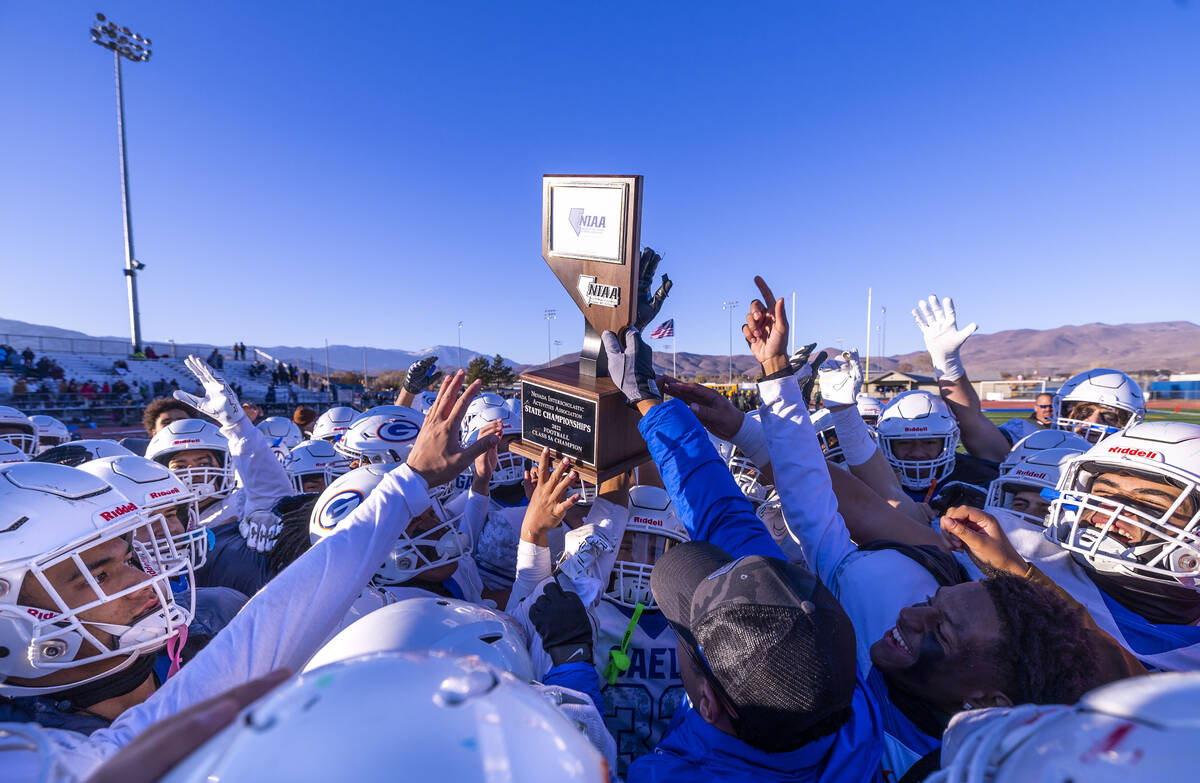 Bishop Gorman head coach Brent Browner presents the winning trophy to his players after defeati ...