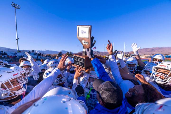 Bishop Gorman head coach Brent Browner presents the winning trophy to his players after defeati ...